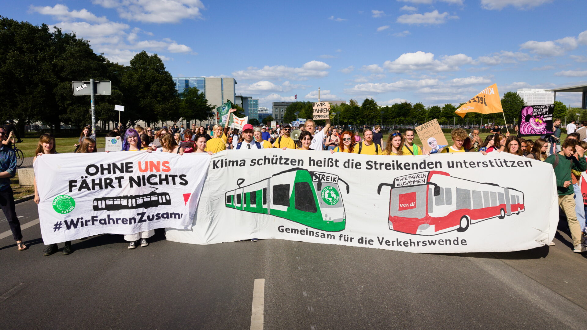 Menschen mit #WirfahrenZusammen Banner