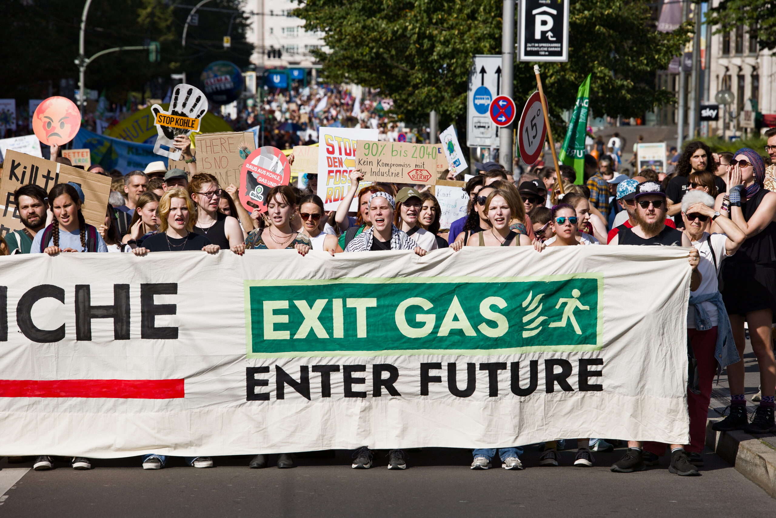 Foto einer Demo, mit vielen Menschen, die ein Banner halten auf dem "Exit Gas Enter Future" steht.